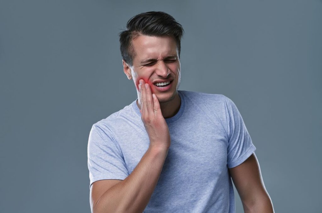 A man holding his jaw in pain